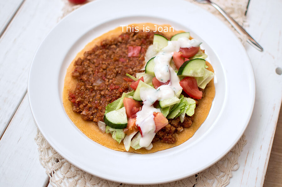 een wit bord met daarop een vegan turkse pizza met sla, tomaat, komkommer en vegan knoflooksaus